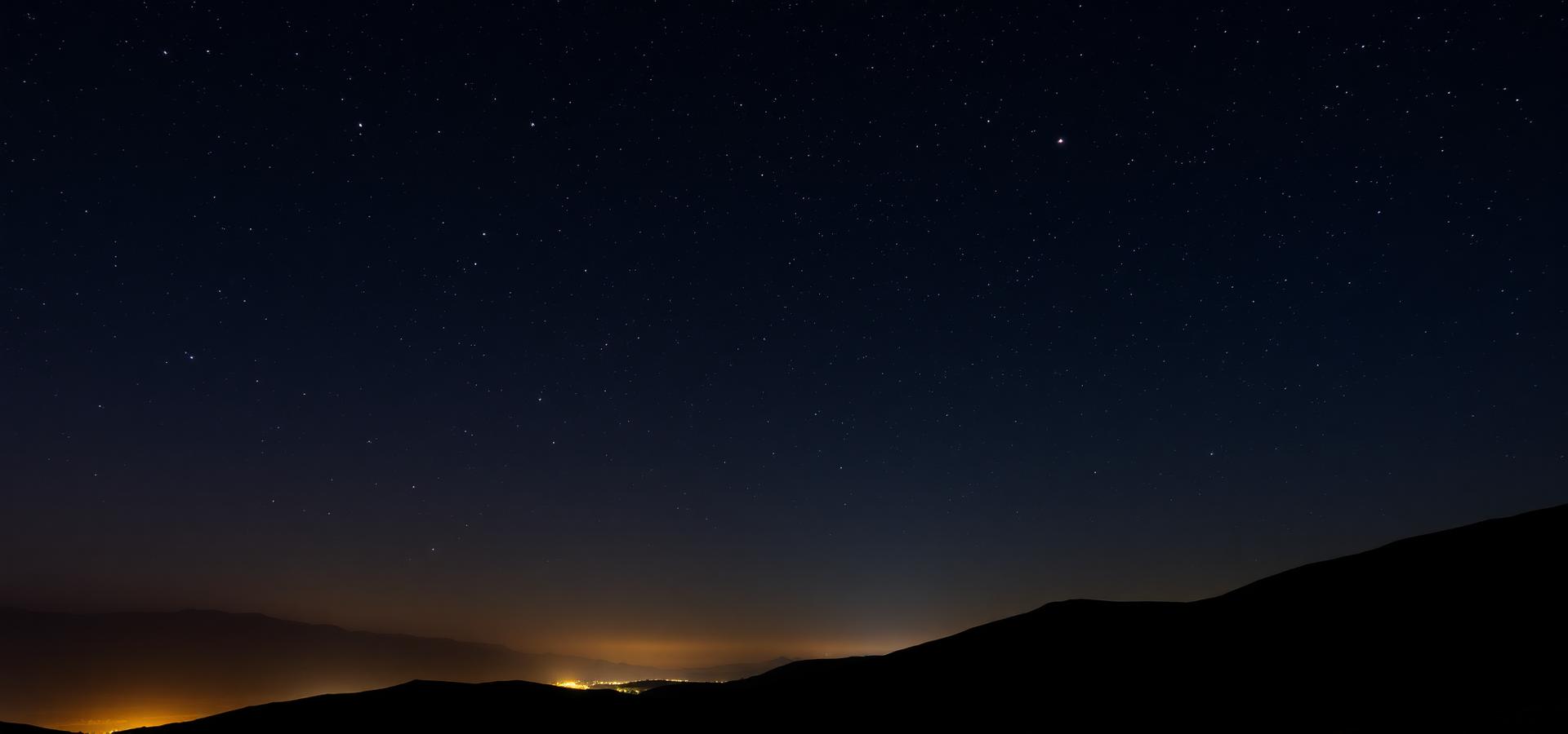 Night sky over silhouetted hills